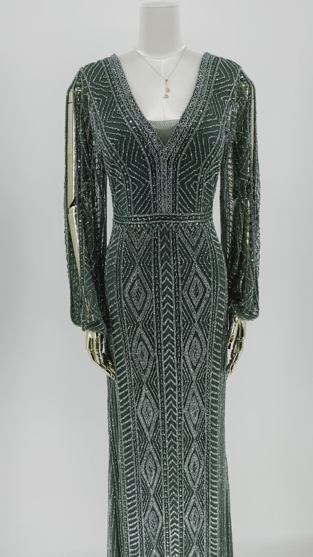 Detaljevisning af Smaragdvævning Gallakjole, fokus på det fine håndarbejde og de luksuriøse smaragdfarvede detaljer, der definerer kjolens eksklusivitet.